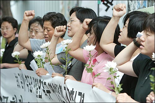 24일 오전 서울 광화문 교보빌딩앞에서 반전평화여성행동 주최로 열린 '고 김선일씨 추모 및 파병철회 촉구 기자회견'에서 조화를 든 참석자들이 파병철회를 촉구하는 구호를 외치고 있다. 